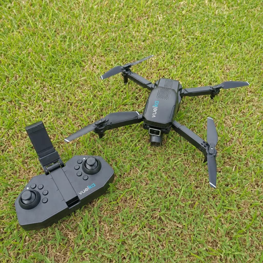 Dron negro y su mando apoyados en el césped